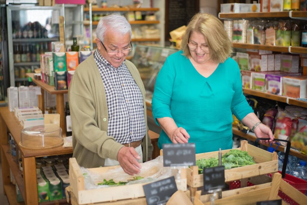 Älteres Paar, Senioren, beim Einkaufen von frischem Gemüse in einem kleinen Laden