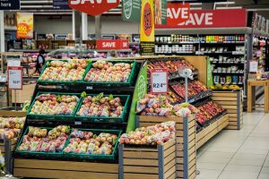 Supermarkt Obst- und Gemüseabteilung Supermarkt Obstabteilung mit Äpfel und Gemüseregalen in einer hellen Umgebung und Deckenhänger, Angebotsschilder und im Hintergrund weitere Regale